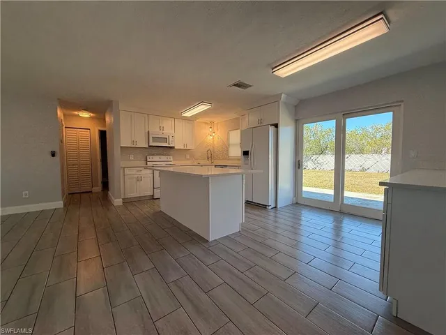 a kitchen with stainless steel appliances granite countertop a refrigerator and a stove top oven