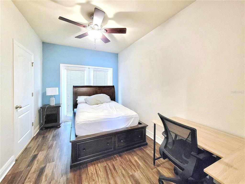 2946 Southwest 35th Place, Unit 44 Gainesville, FL 32608 - Photo 12 of 25 a bedroom with a bed and wooden floor
