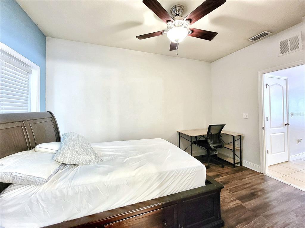 2946 Southwest 35th Place, Unit 44 Gainesville, FL 32608 - Photo 13 of 25 a bedroom with a large bed and a chandelier