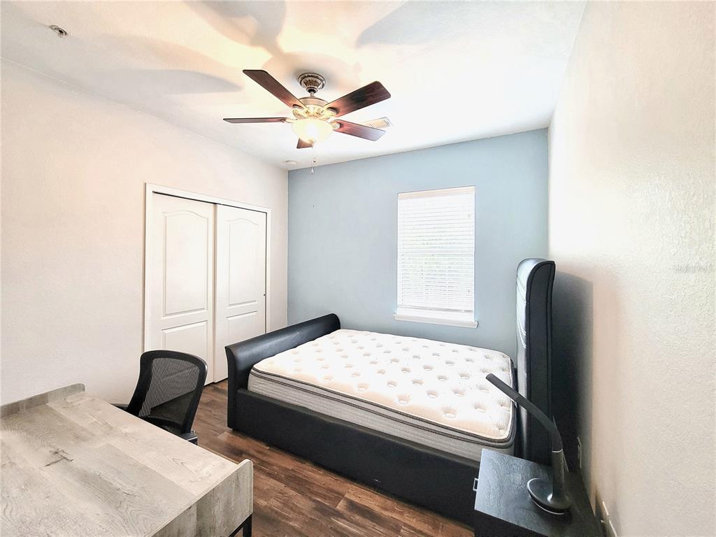 2946 Southwest 35th Place, Unit 44 Gainesville, FL 32608 - Photo 19 of 25 a bedroom with a bed and a large mirror