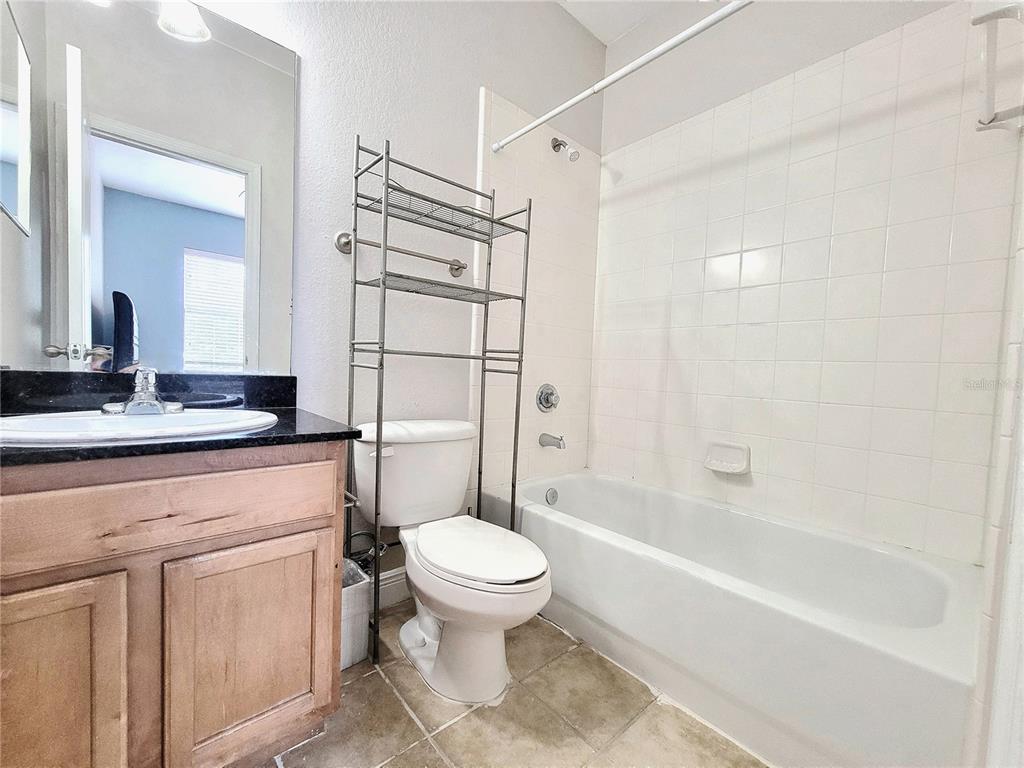 2946 Southwest 35th Place, Unit 44 Gainesville, FL 32608 - Photo 20 of 25 a bathroom with a granite countertop sink toilet and shower