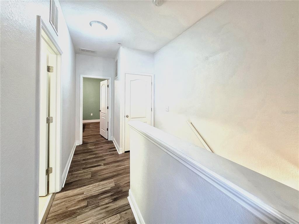 2946 Southwest 35th Place, Unit 44 Gainesville, FL 32608 - Photo 21 of 25 a view of a hallway with wooden floor and staircase