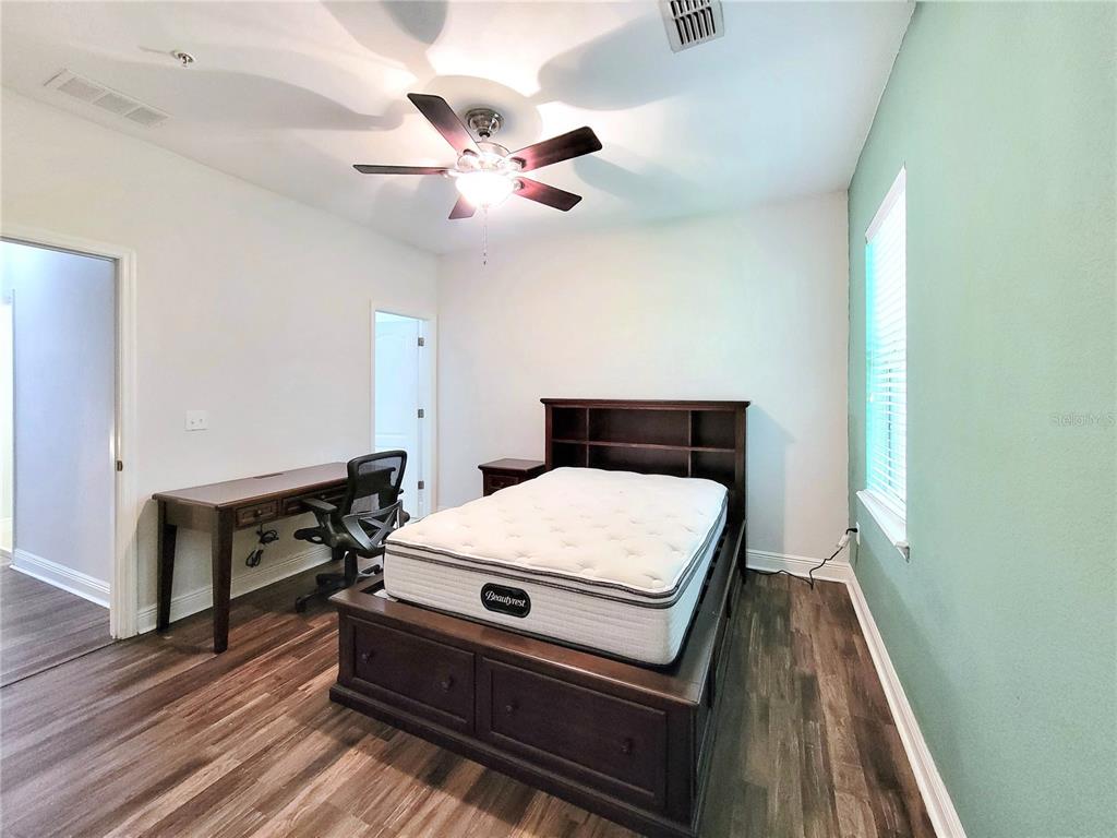 2946 Southwest 35th Place, Unit 44 Gainesville, FL 32608 - Photo 23 of 25 a bed room with a bed and a chandelier