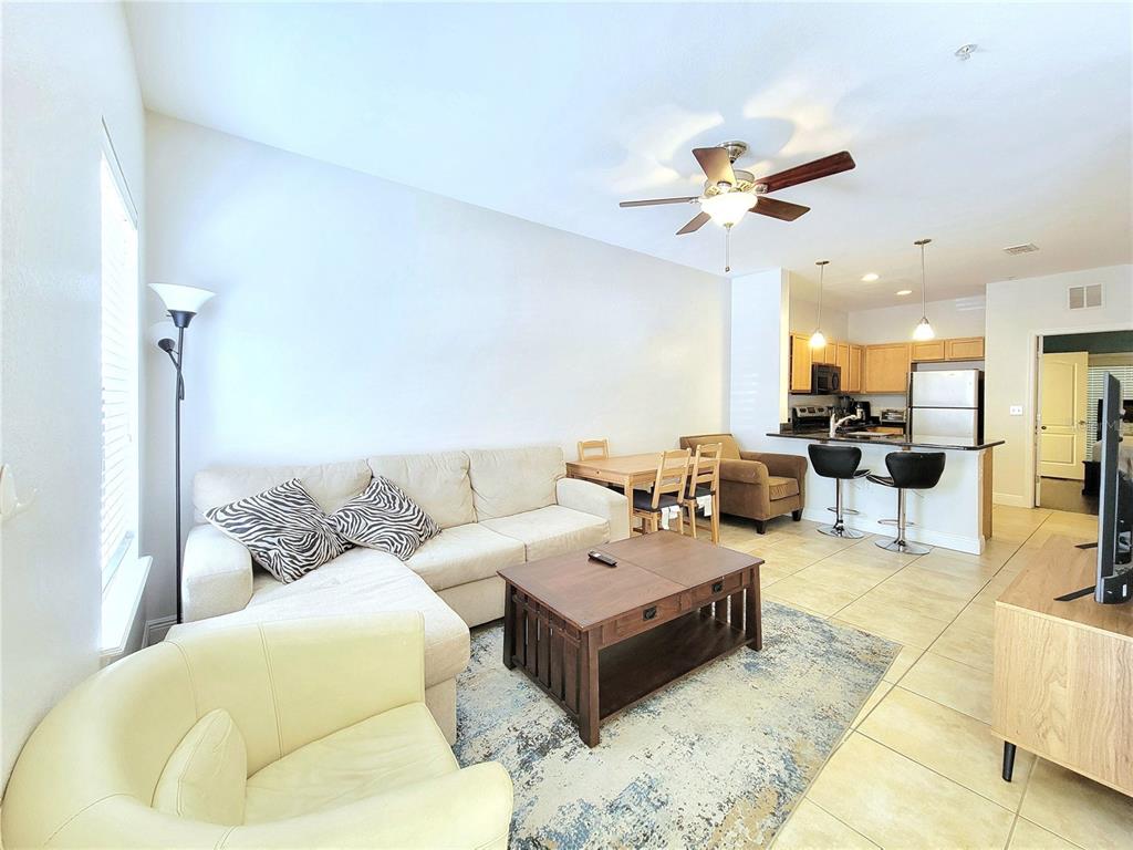 2946 Southwest 35th Place, Unit 44 Gainesville, FL 32608 - Photo 5 of 25 a living room with furniture kitchen view and a chandelier