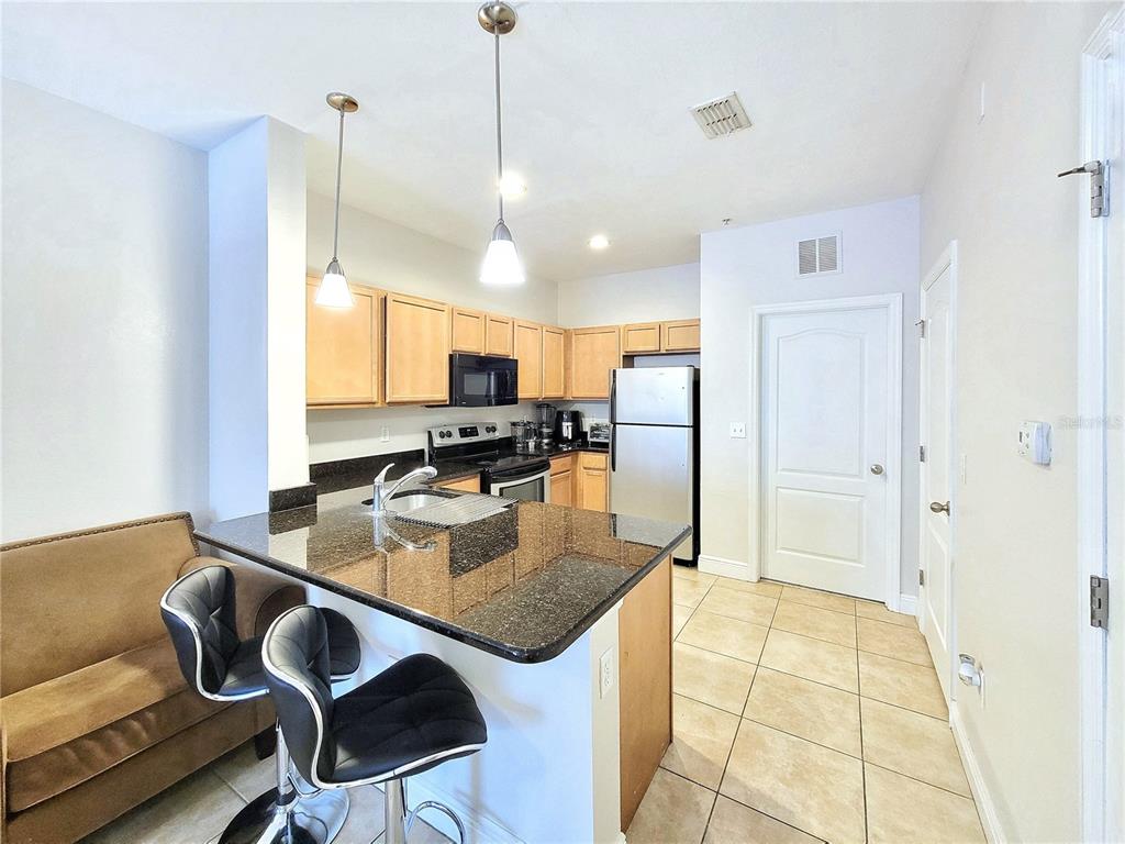 2946 Southwest 35th Place, Unit 44 Gainesville, FL 32608 - Photo 9 of 25 a kitchen with a dining table chairs and refrigerator