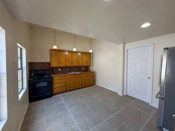 a kitchen with a refrigerator and a stove top oven