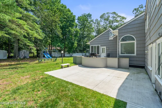 a view of a house with backyard and a tree