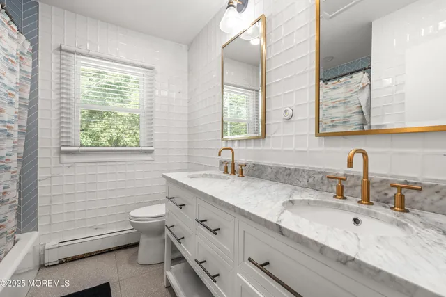 a bathroom with a granite countertop toilet sink and mirror