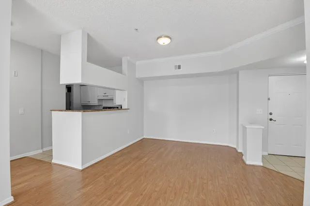 a view of empty room with wooden floor and ceiling fan