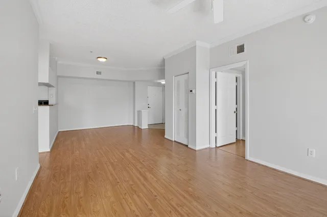 a walk in closet with wooden floor
