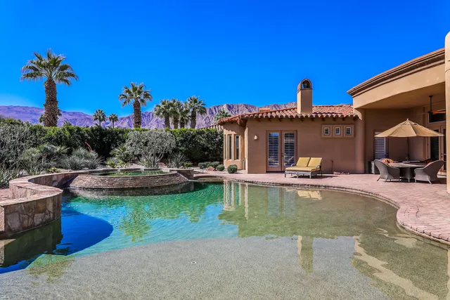a living room with furniture a bookshelf and a large window