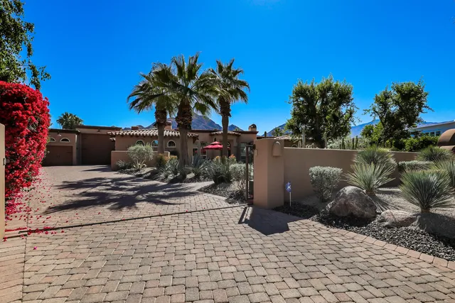 a front view of a house with a yard and garden