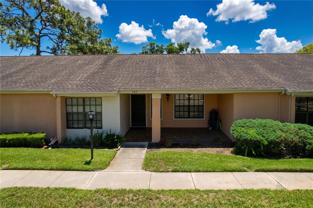 9319 Trowbridge Court New Port Richey, FL 34655 - Photo 2 of 78 a front view of a house with a yard and potted plants