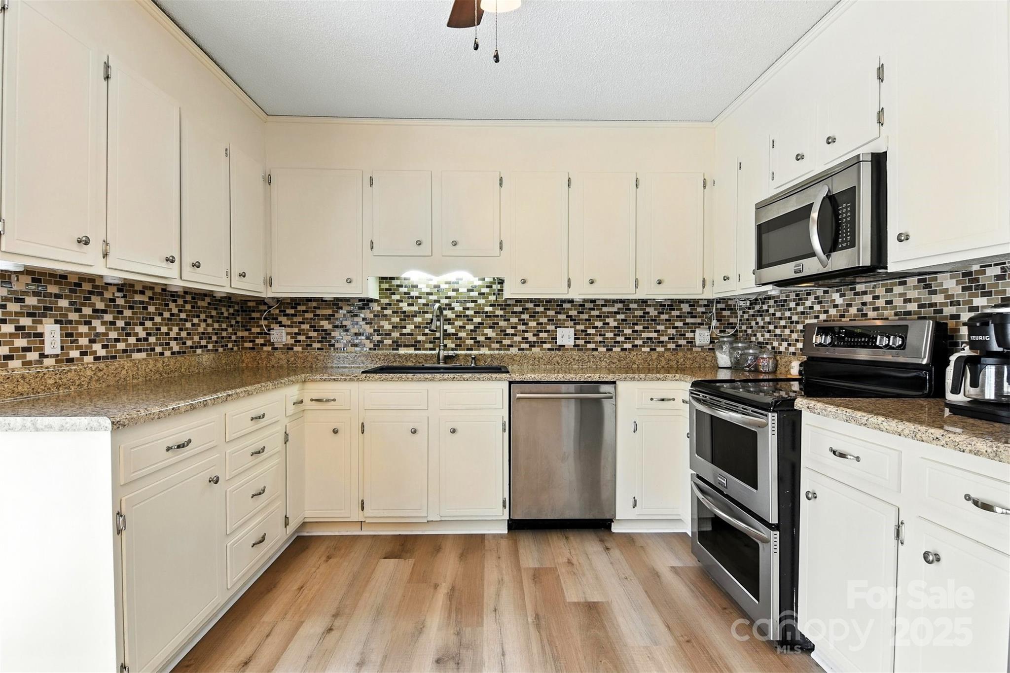 952 30th Street Northeast Conover, NC 28613 - Photo 16 of 36 a kitchen with granite countertop white cabinets and stainless steel appliances