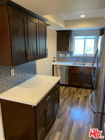 a kitchen with a sink cabinets and wooden floor