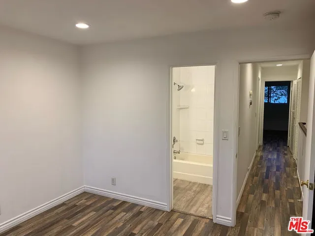 a view of a hallway with wooden floor and closet