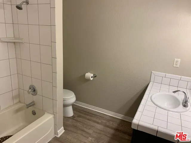 a bathroom with a granite countertop toilet a sink and bathtub