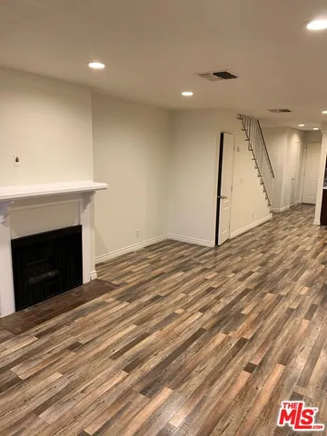 a view of empty room with wooden floor and fireplace