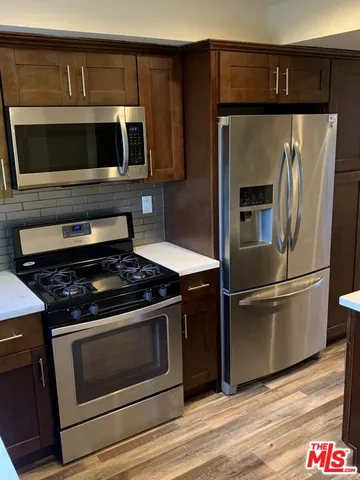 a kitchen with stainless steel appliances and wooden cabinets