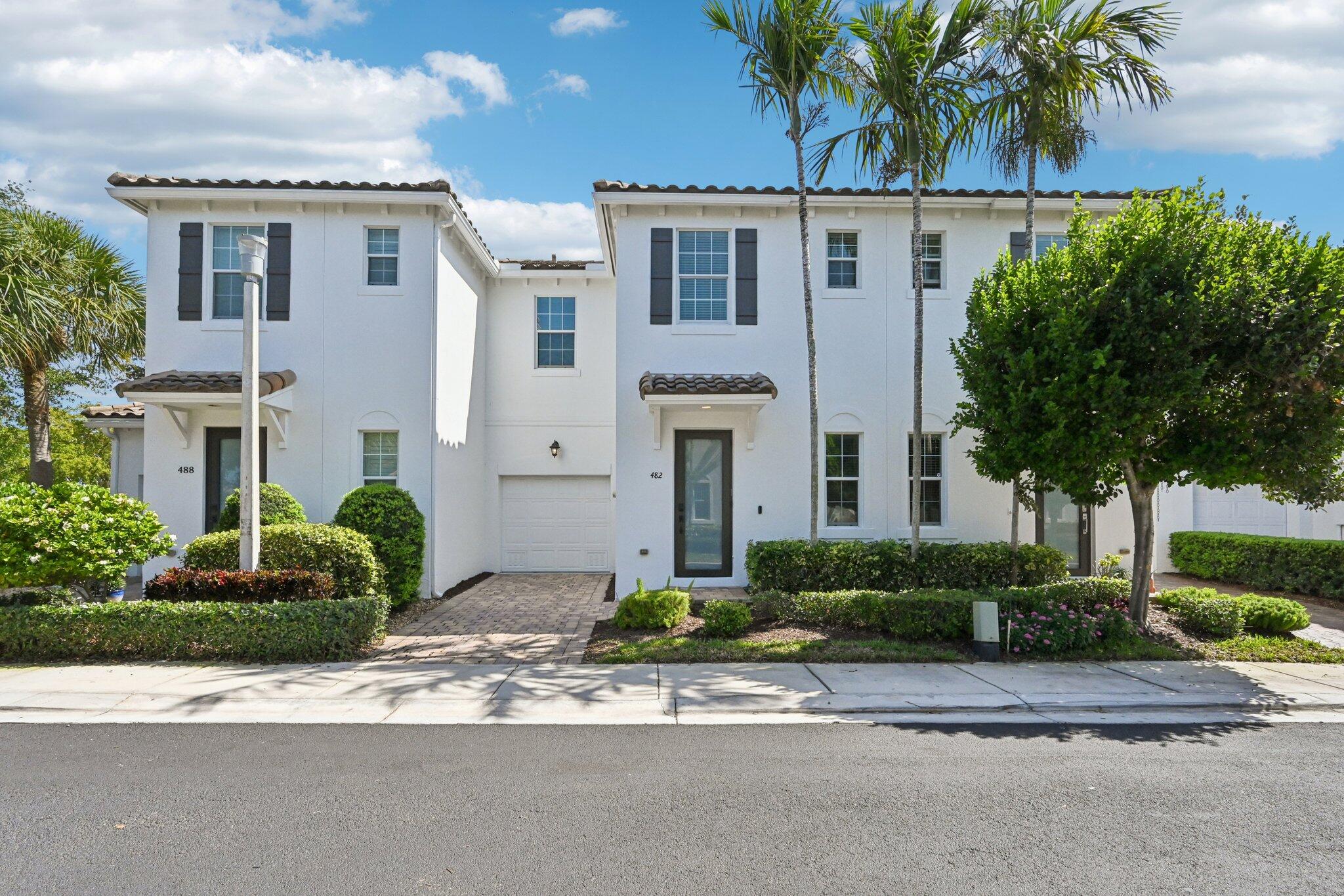 482 Graham Place Boynton Beach, FL 33435 - Photo 1 of 39 a front view of a house with a yard and potted plants