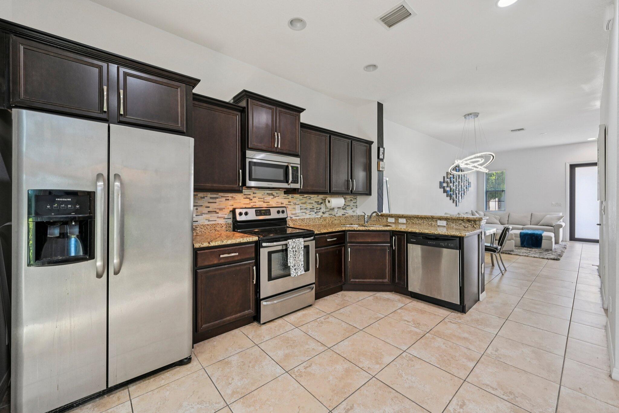 482 Graham Place Boynton Beach, FL 33435 - Photo 8 of 39 a kitchen with stainless steel appliances granite countertop a refrigerator sink and stove