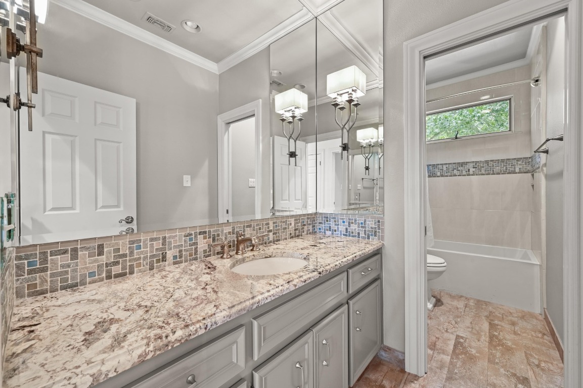 4207 Bennedict Lane Austin, TX 78746 - Photo 17 of 27 a bathroom with a granite countertop sink a toilet and a mirror