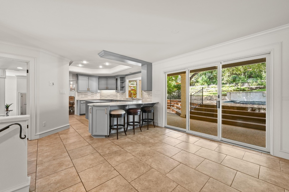 4207 Bennedict Lane Austin, TX 78746 - Photo 9 of 27 a open kitchen with kitchen island granite countertop a sink and cabinets