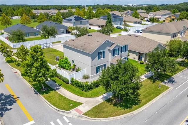 an aerial view of a house with a garden and lake view