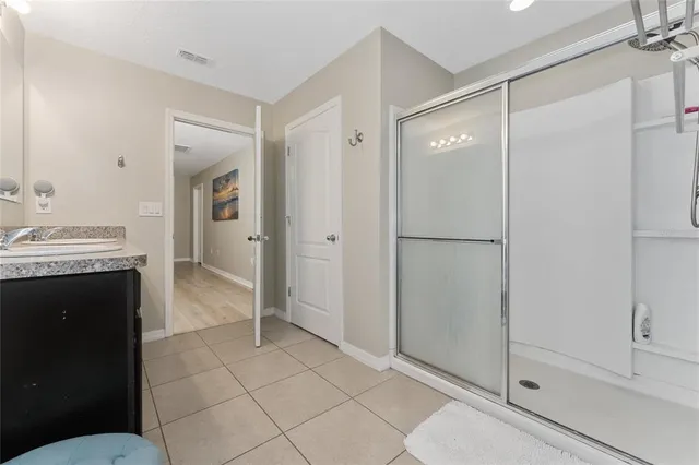 a bathroom with a glass shower door and a sink