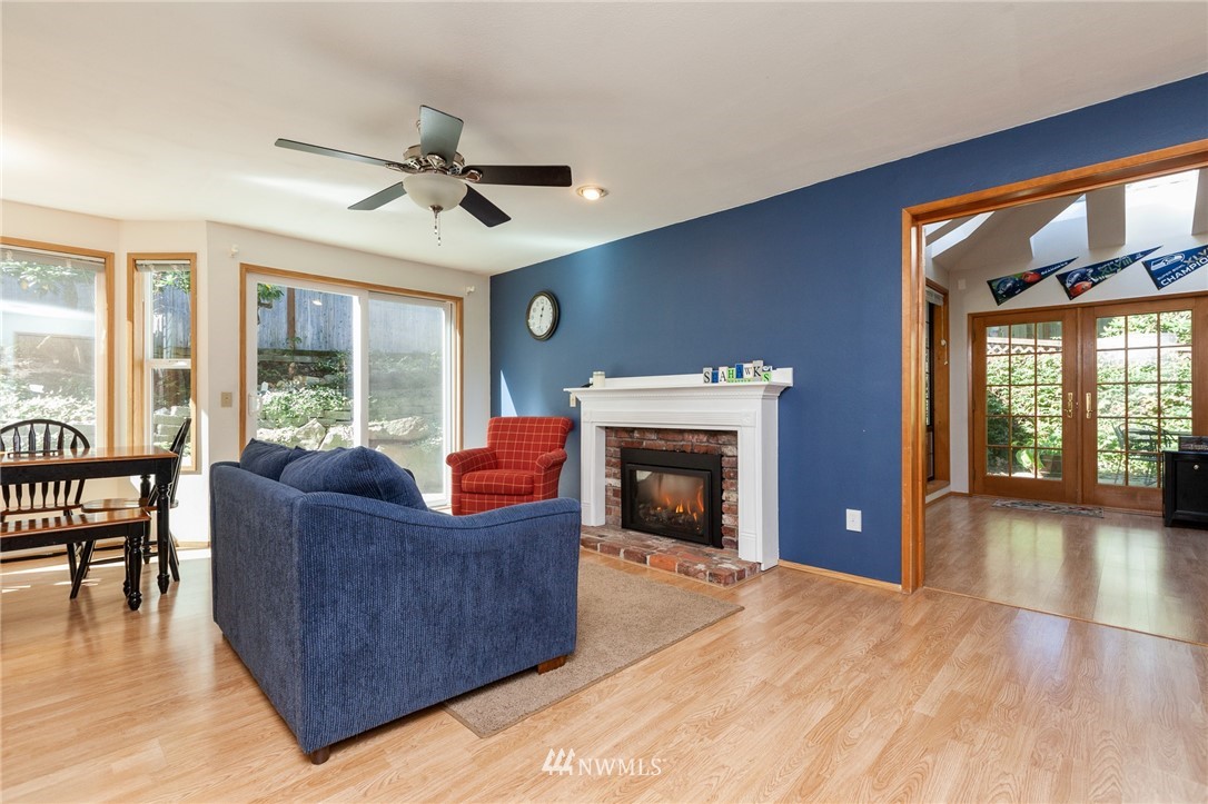 21814 4th Avenue Southeast Bothell, WA 98021 - Photo 6 of 25 a living room with furniture a fireplace and a floor to ceiling window