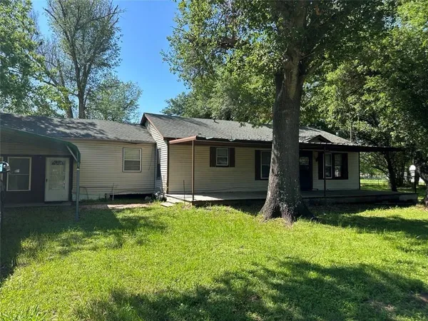 a backyard of a house with yard and tree