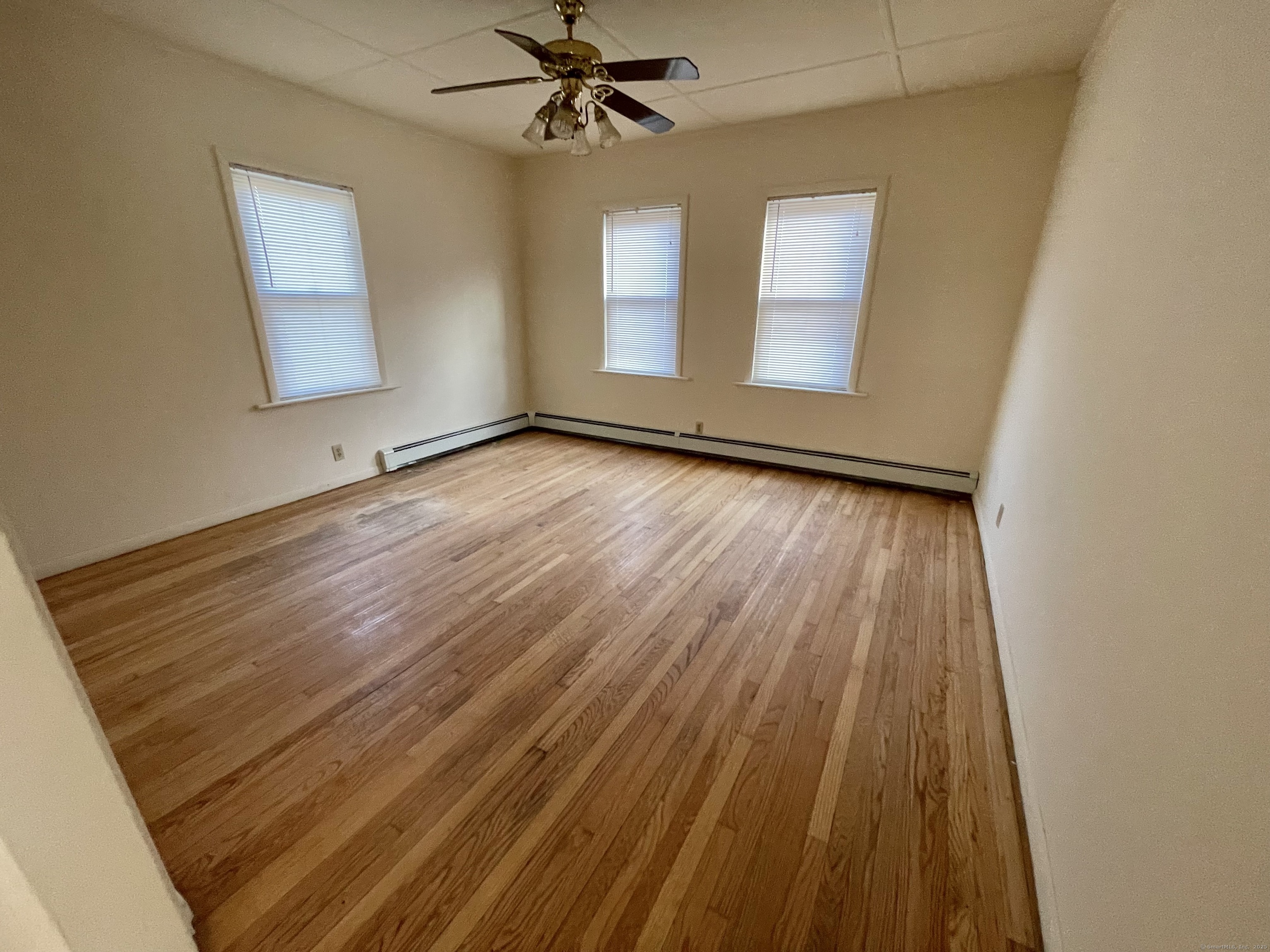 25 Pleasant Street Ansonia, CT 06401 - Photo 19 of 25 an empty room with wooden floor chandelier fan and windows