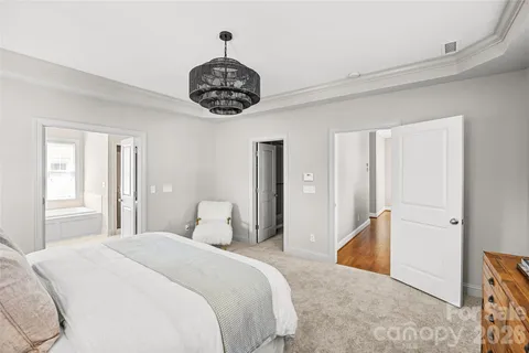 a bedroom with a bed and a chandelier