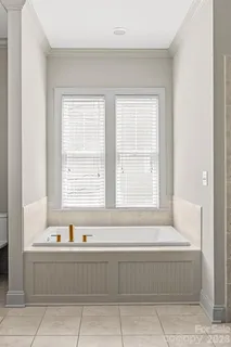 a bathroom with bathtub and next to a window