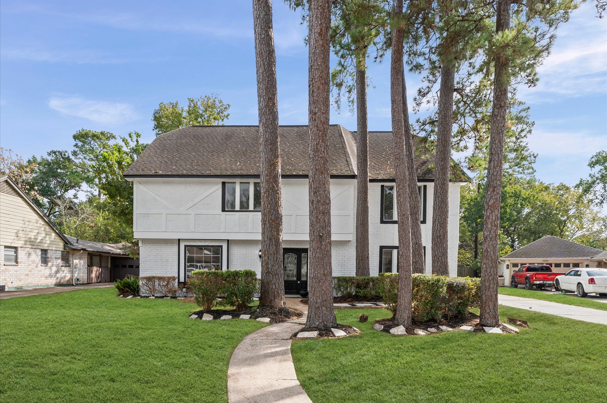 a front view of a house with a garden and tree