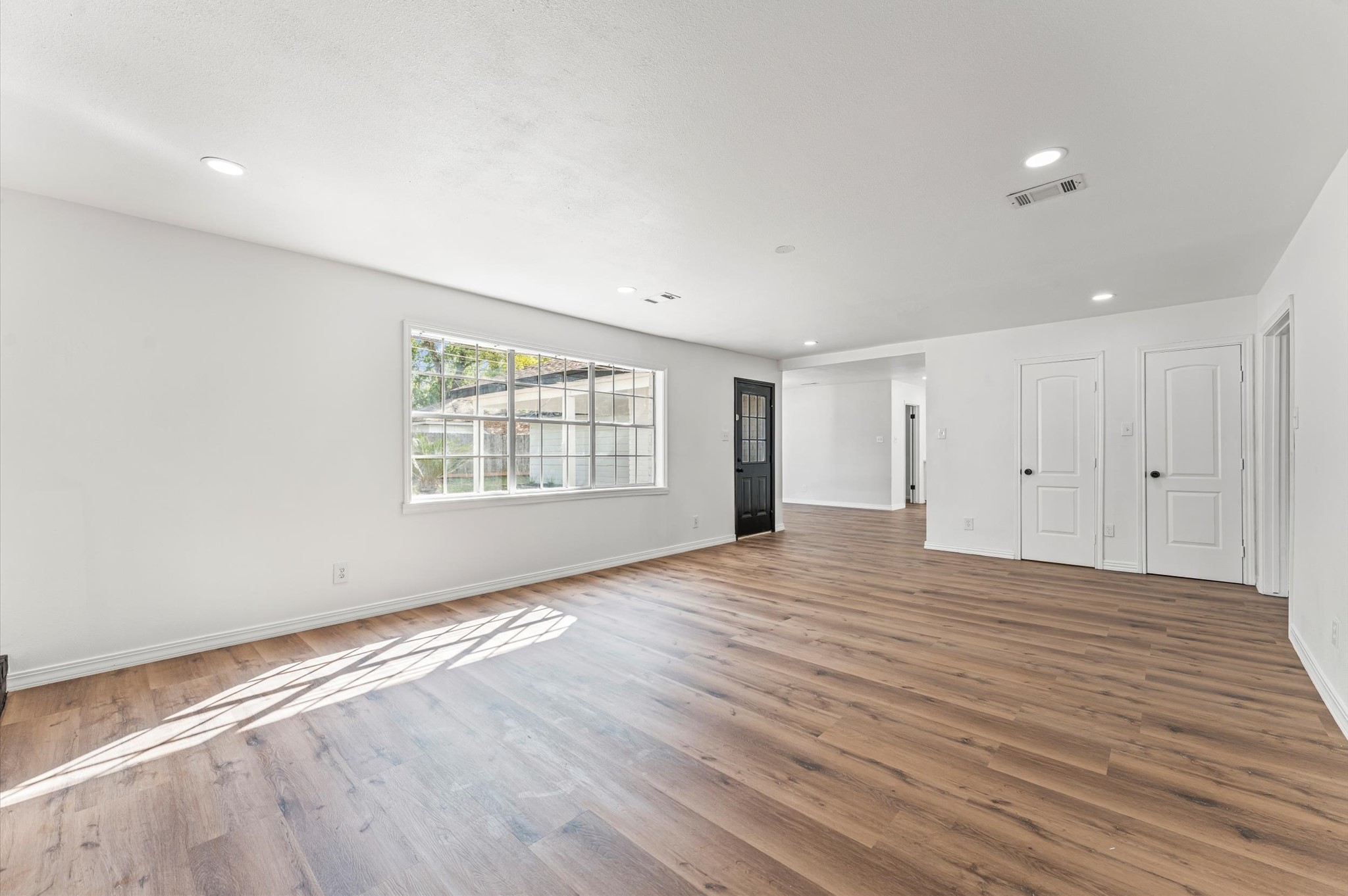 1123 Suwanee Lane Houston, TX 77090 - Photo 13 of 39 a view of an empty room with wooden floor and a window