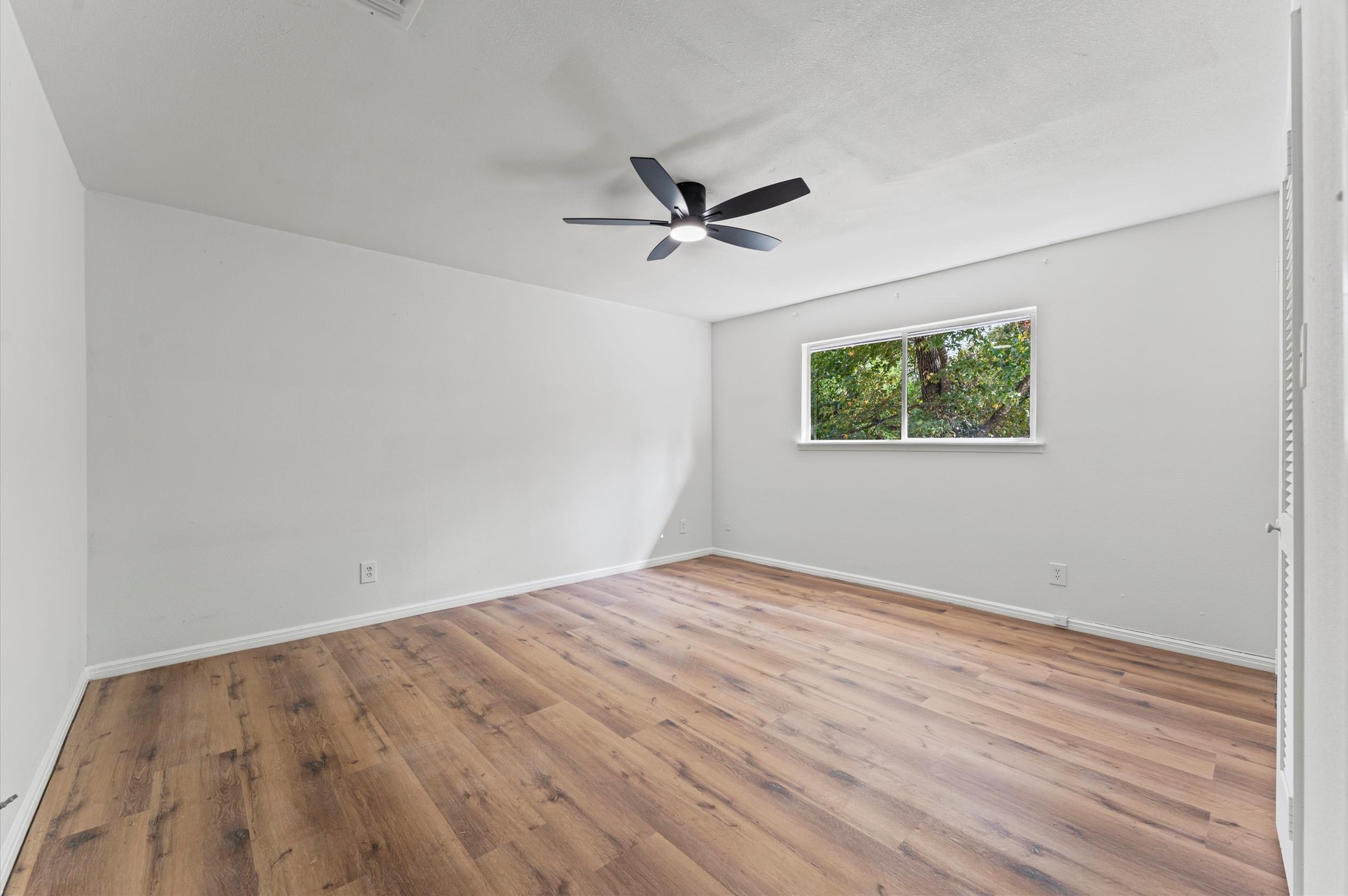 1123 Suwanee Lane Houston, TX 77090 - Photo 23 of 39 an empty room with wooden floor ceiling fan and windows