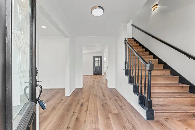 a view of a hallway with wooden floor and staircase