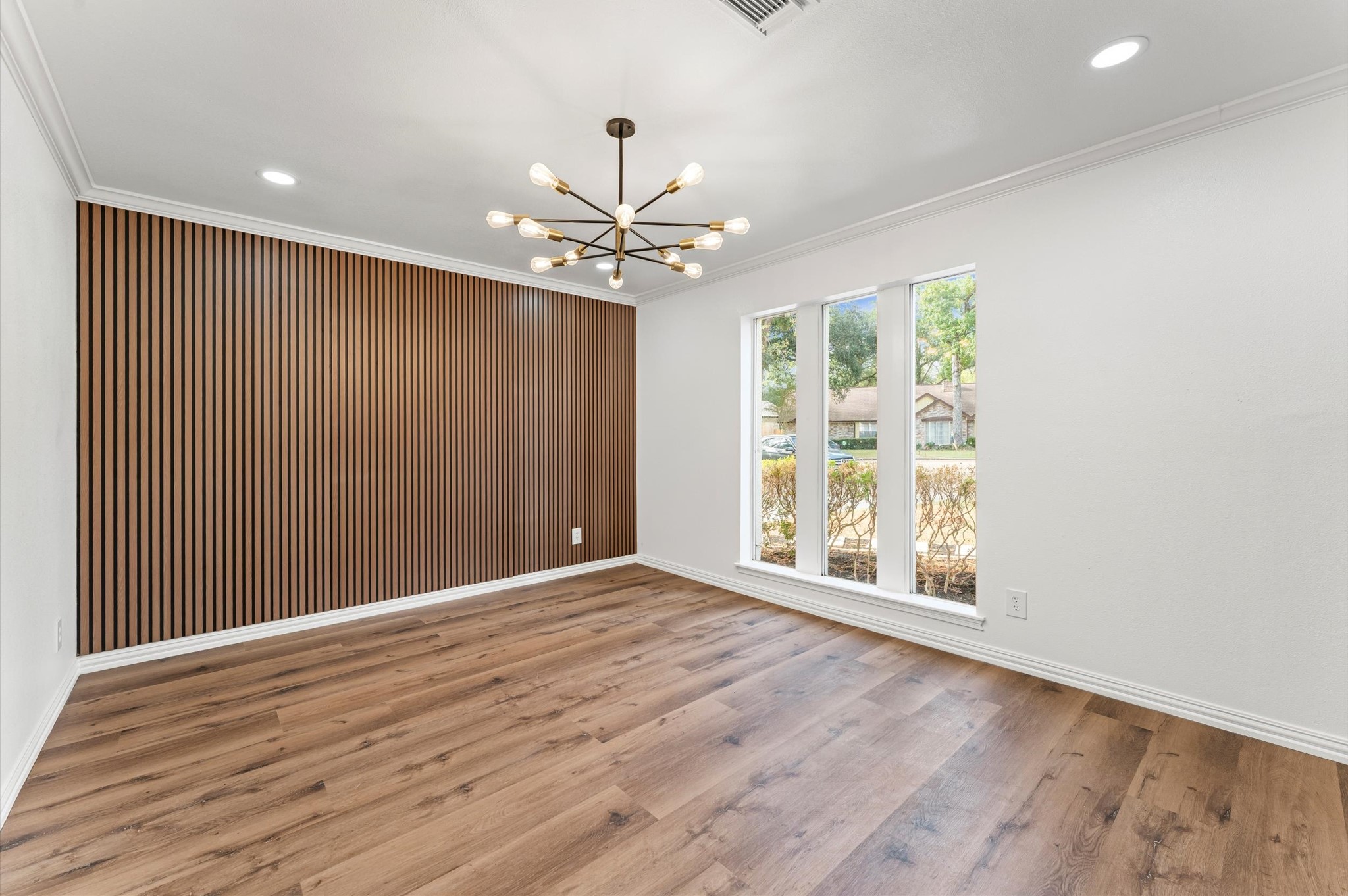 1123 Suwanee Lane Houston, TX 77090 - Photo 5 of 39 an empty room with wooden floor chandelier fan and windows