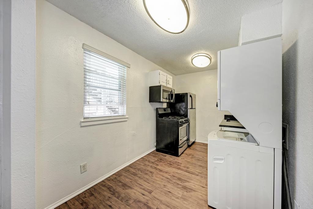 2401 Manor Road, Unit 133 Austin, TX 78722 - Photo 12 of 20 Functional kitchen space featuring modern appliances and durable wood flooring.
