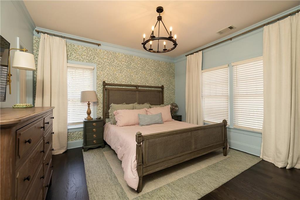 6810 Lullwater Road Cumming, GA 30040 - Photo 34 of 63 a bedroom with a bed and a chandelier