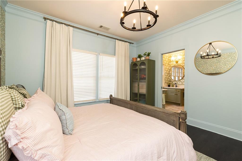 6810 Lullwater Road Cumming, GA 30040 - Photo 36 of 63 a bedroom with a bed a mirror and a window