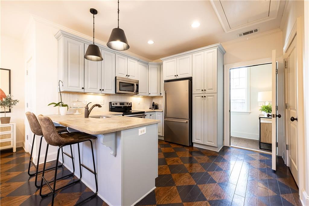 6810 Lullwater Road Cumming, GA 30040 - Photo 48 of 63 a kitchen with stainless steel appliances granite countertop a sink a stove a refrigerator and island with wooden floor