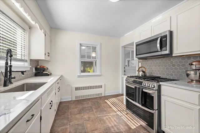 a kitchen with stainless steel appliances granite countertop a sink stove oven and microwave