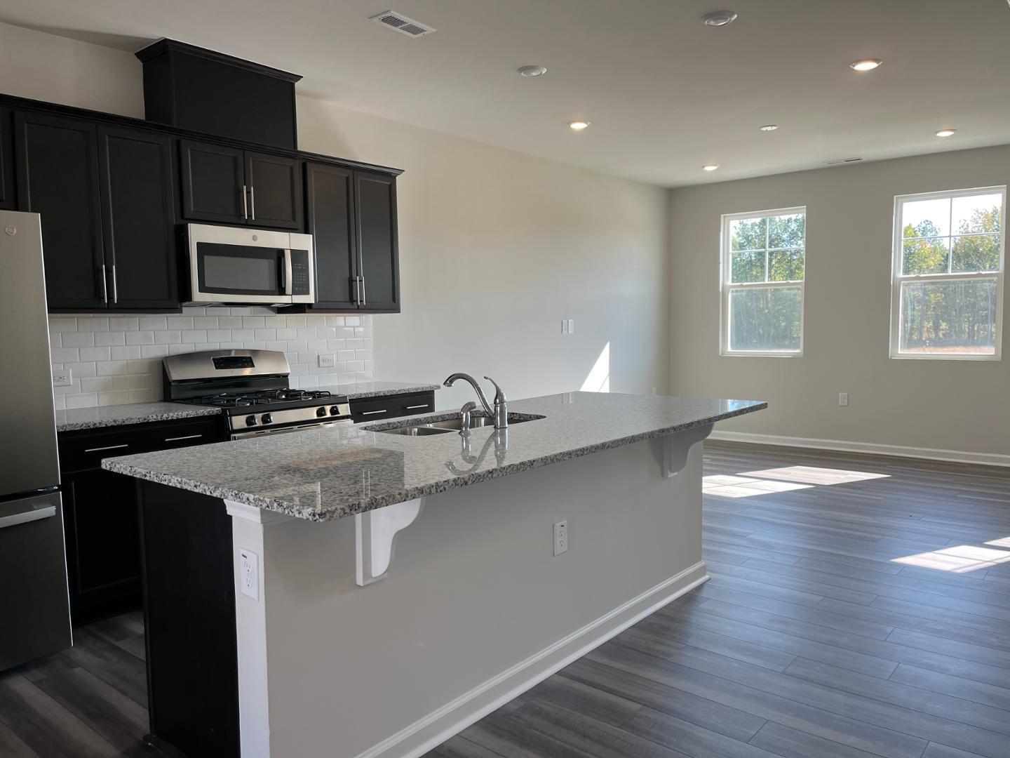 1918 Rosedale Rdg Avenue Wake Forest, NC 27587 - Photo 9 of 18 a kitchen with stainless steel appliances granite countertop a sink a stove and a microwave
