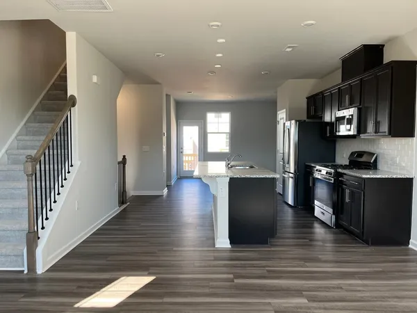 a kitchen with stainless steel appliances granite countertop a refrigerator a stove and a wooden floors