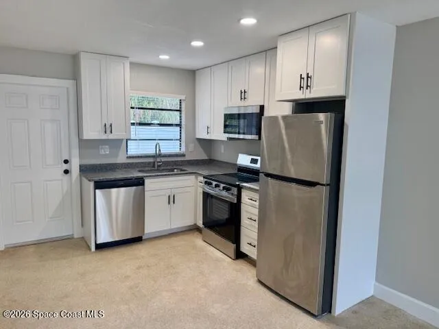 a kitchen with stainless steel appliances granite countertop a refrigerator sink and cabinets