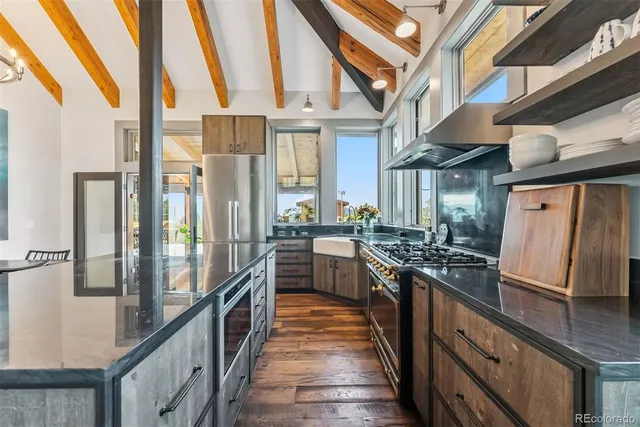 a kitchen with stainless steel appliances granite countertop lots of counter top space and wooden floor