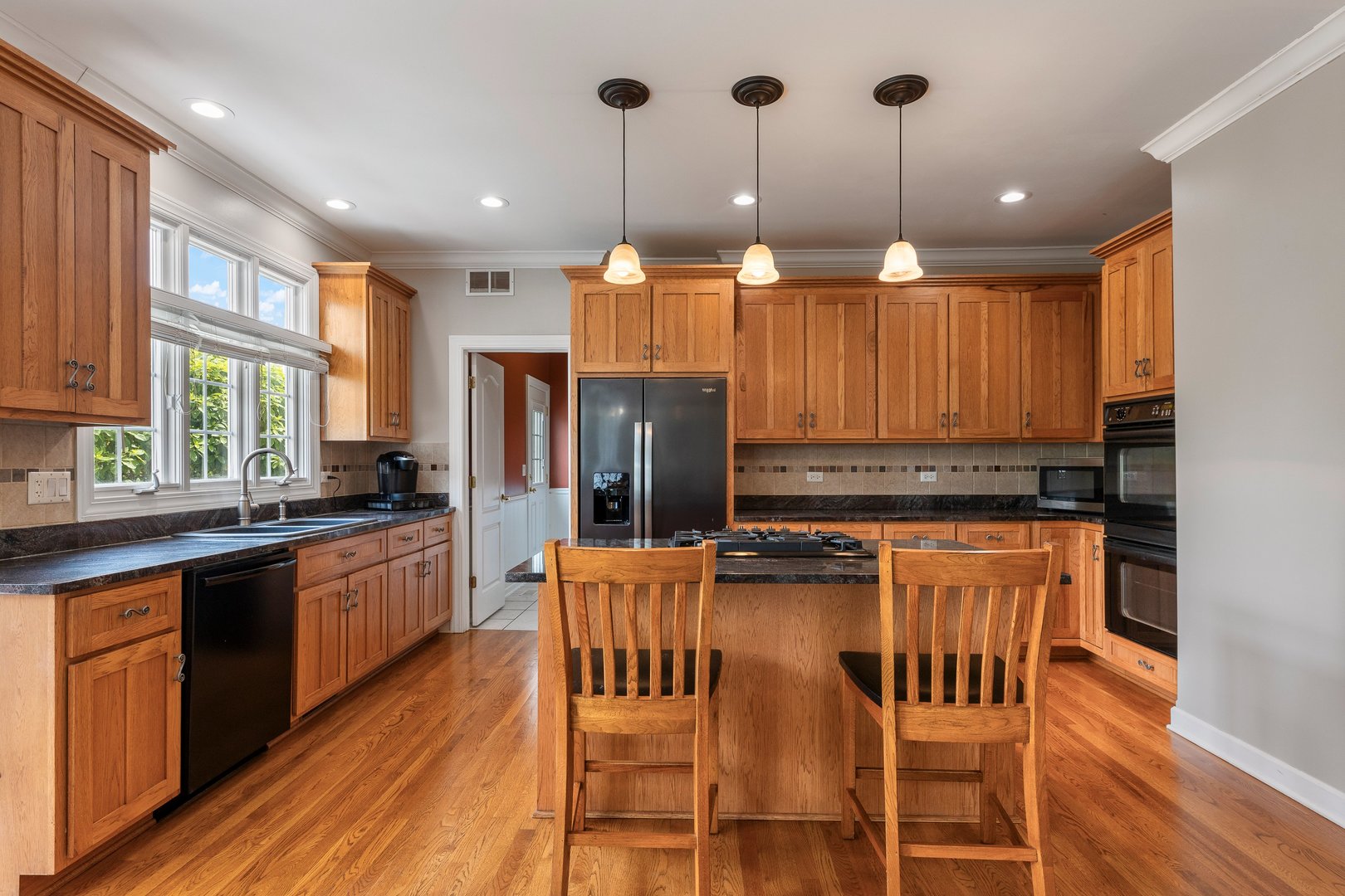 2531 Spartina Road Naperville, IL 60564 - Photo 5 of 39 a kitchen with stainless steel appliances kitchen island granite countertop a stove top oven a refrigerator with island and chairs