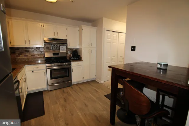 a kitchen with a sink cabinets and wooden floor